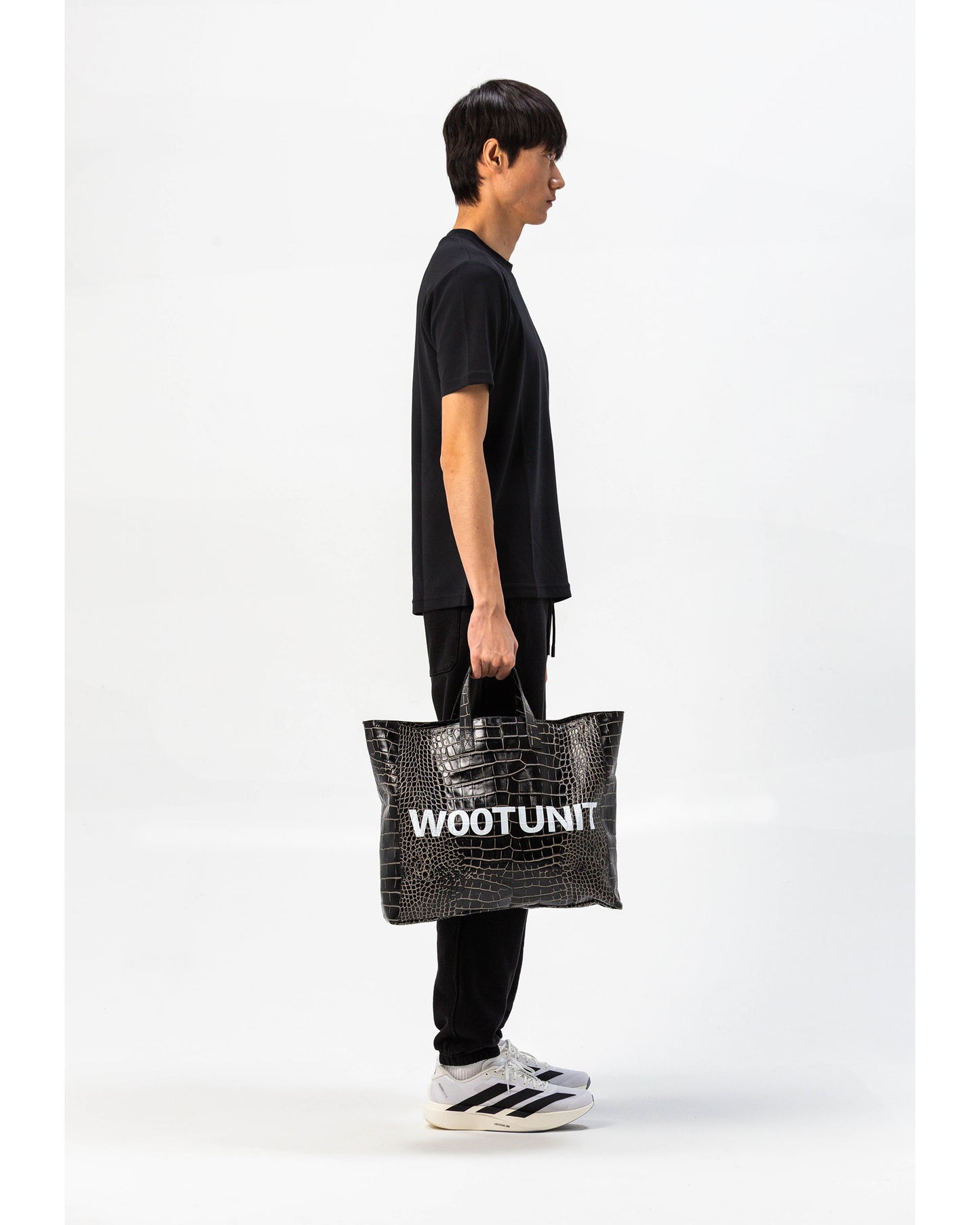 Borsa in pelle nera WOOTUNIT design coccodrillo con logo oversize vista laterale