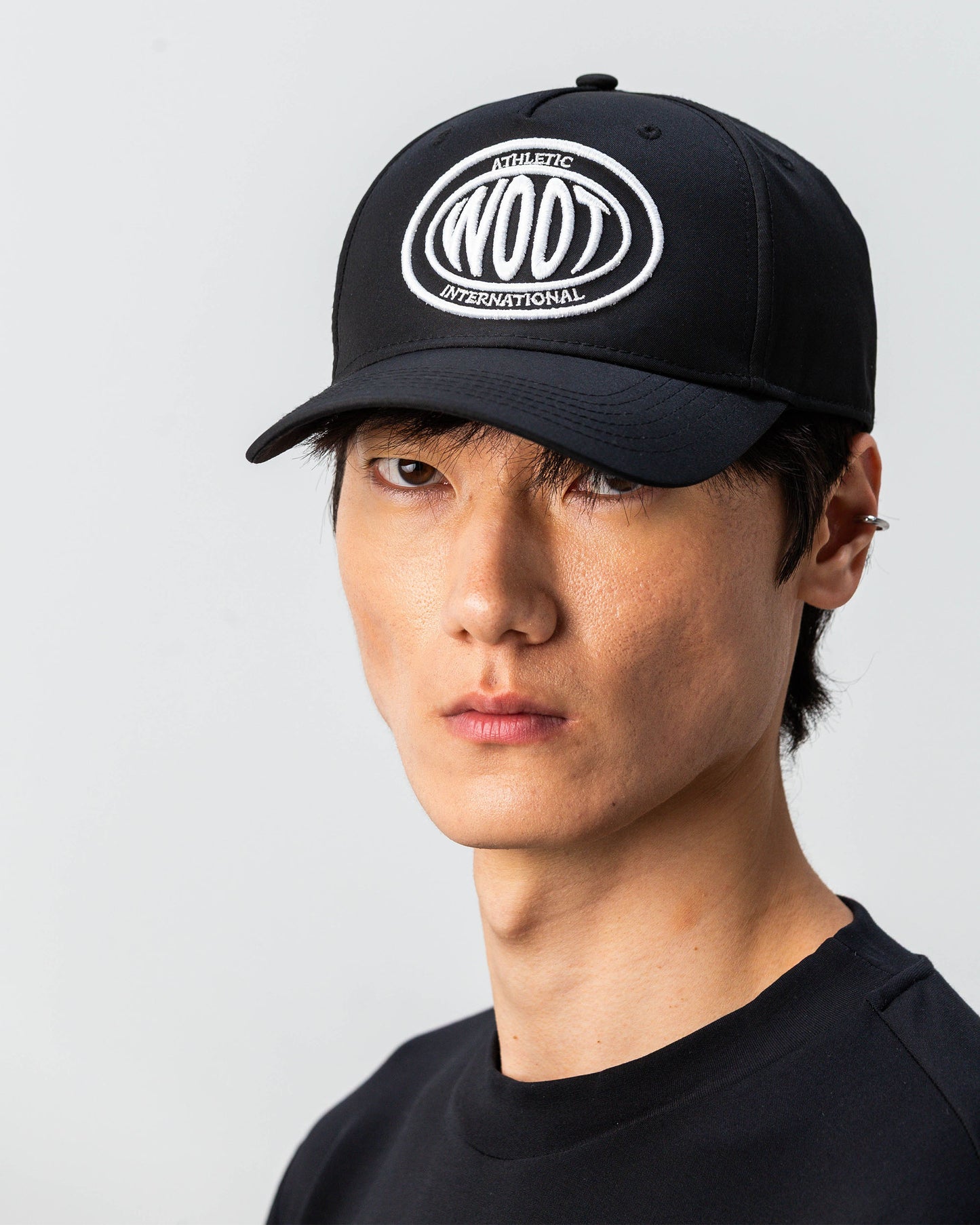 Modello indossa cappellino sportivo bianco WOOTUNIT con logo WOOT ricamato vista LATERALE