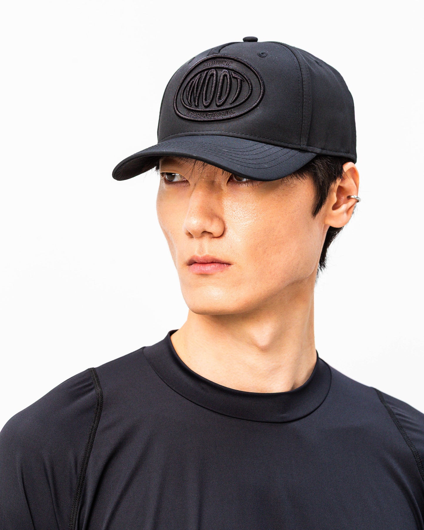 Modello indossa cappellino sportivo nero WOOTUNIT con logo WOOT ricamato vista LATERALE