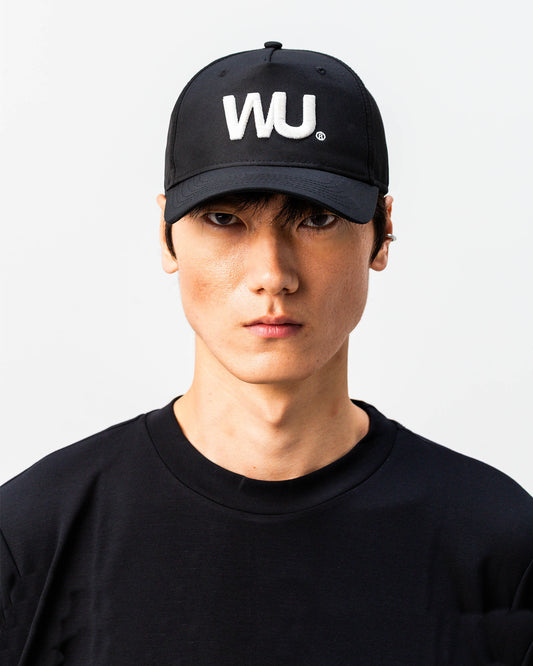 Modello indossa cappellino sportivo bianco WOOTUNIT con logo WU ricamato vista frontale