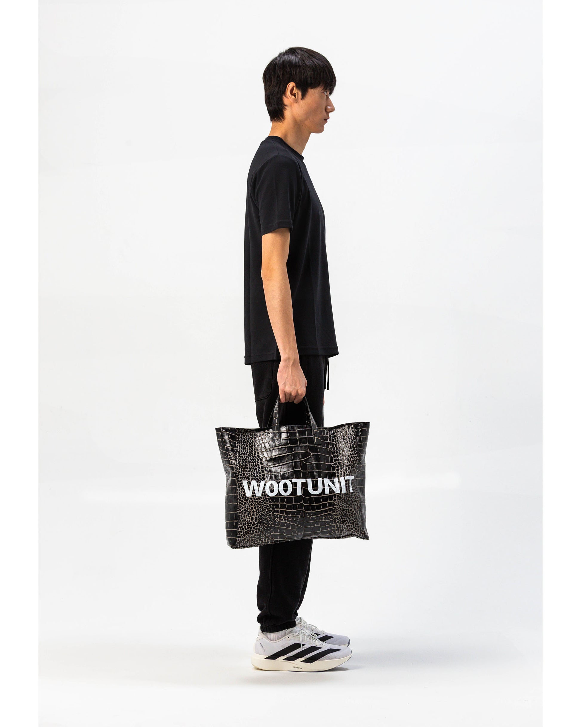 Borsa in pelle nera WOOTUNIT design coccodrillo con logo oversize vista laterale