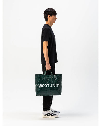 Modello indossa borsa in pelle verde WOOTUNIT design coccodrillo oversize figura intera