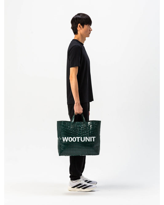 Modello indossa borsa in pelle verde WOOTUNIT design coccodrillo oversize figura intera