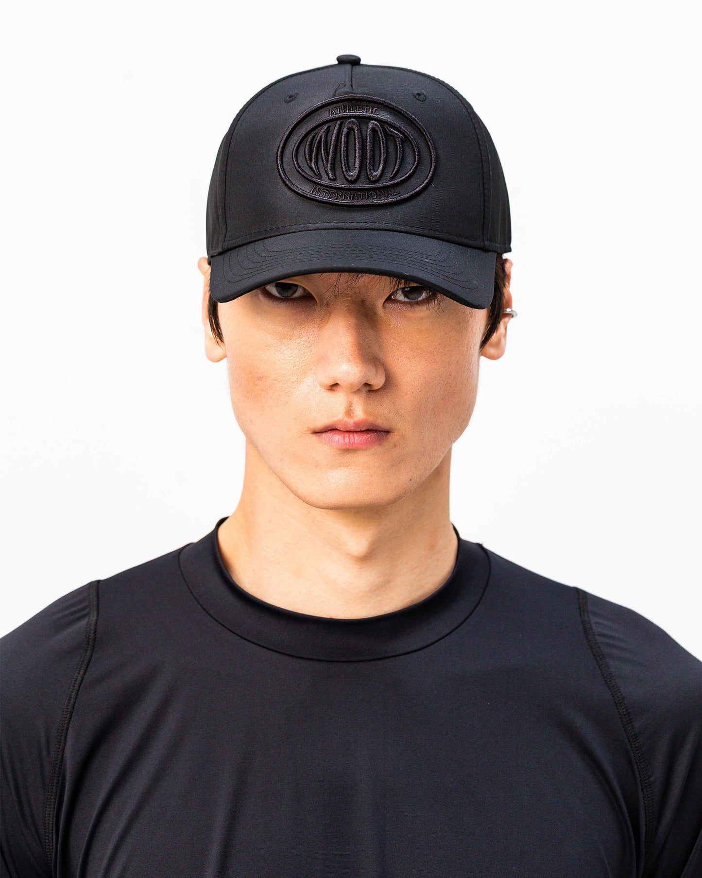 Modello indossa cappellino sportivo nero WOOTUNIT con logo WOOT ricamato vista frontale