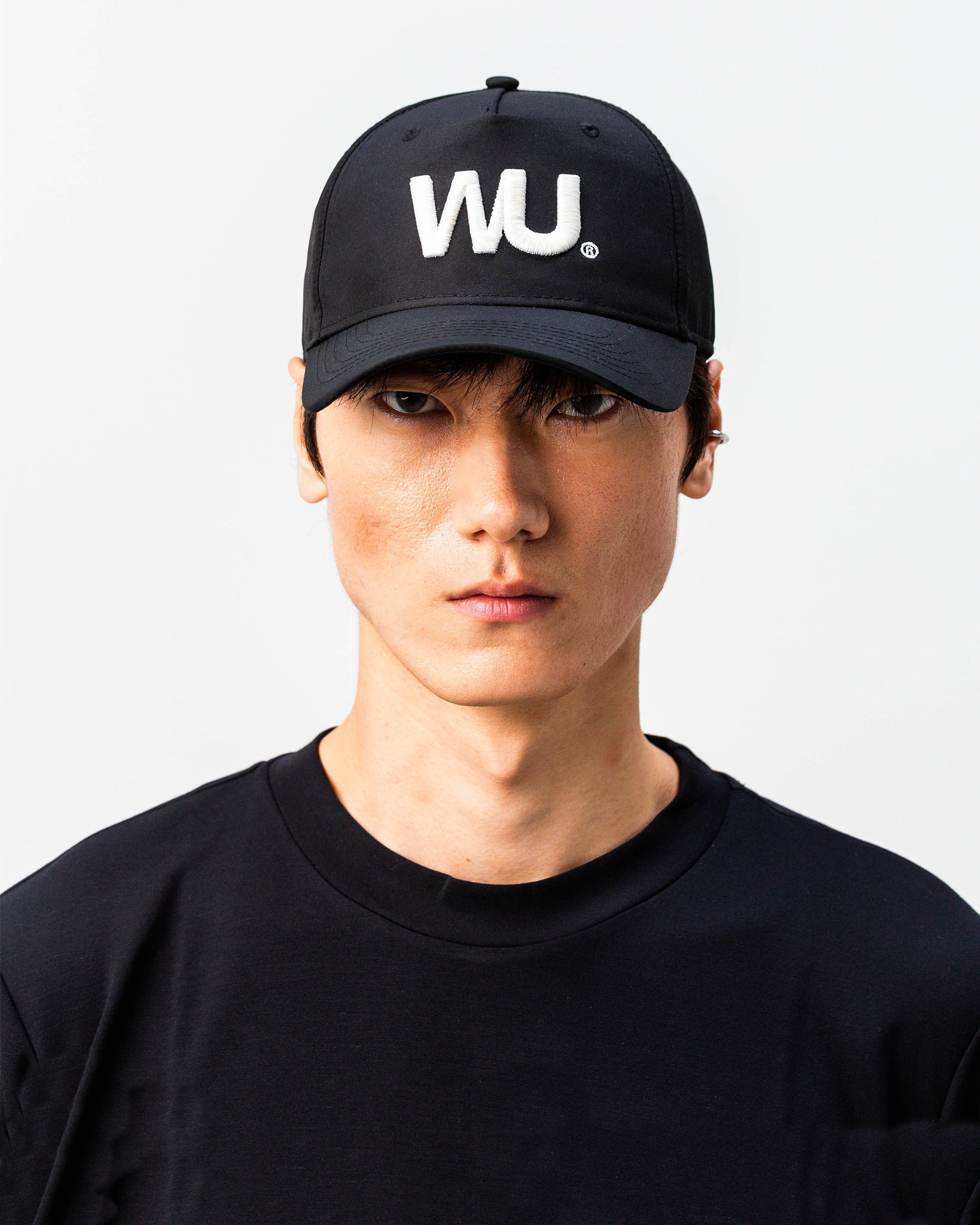 Modello indossa cappellino sportivo bianco WOOTUNIT con logo WU ricamato vista frontale