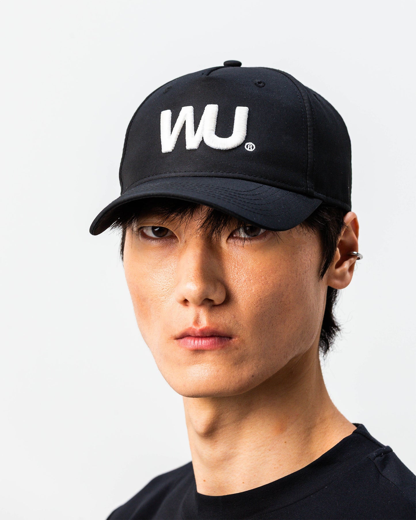 Modello indossa cappellino sportivo bianco WOOTUNIT con logo WU ricamato vista frontale